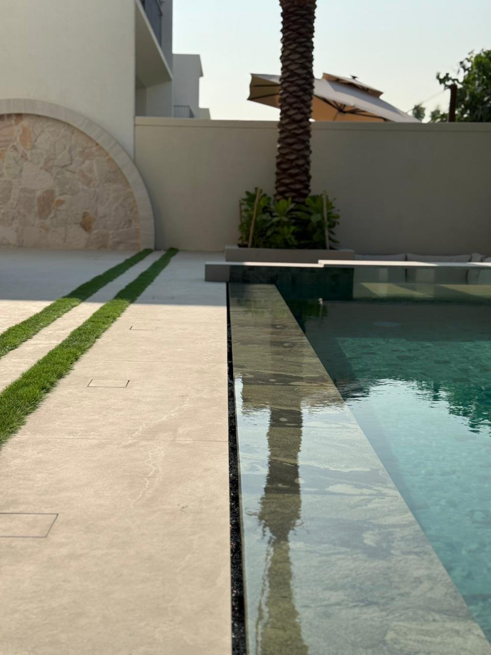 Arched stone feature wall with grass channel paving