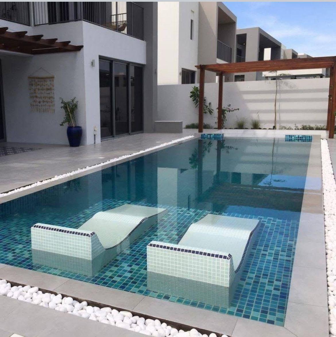 Sunken seating area with fire feature and canal view at night