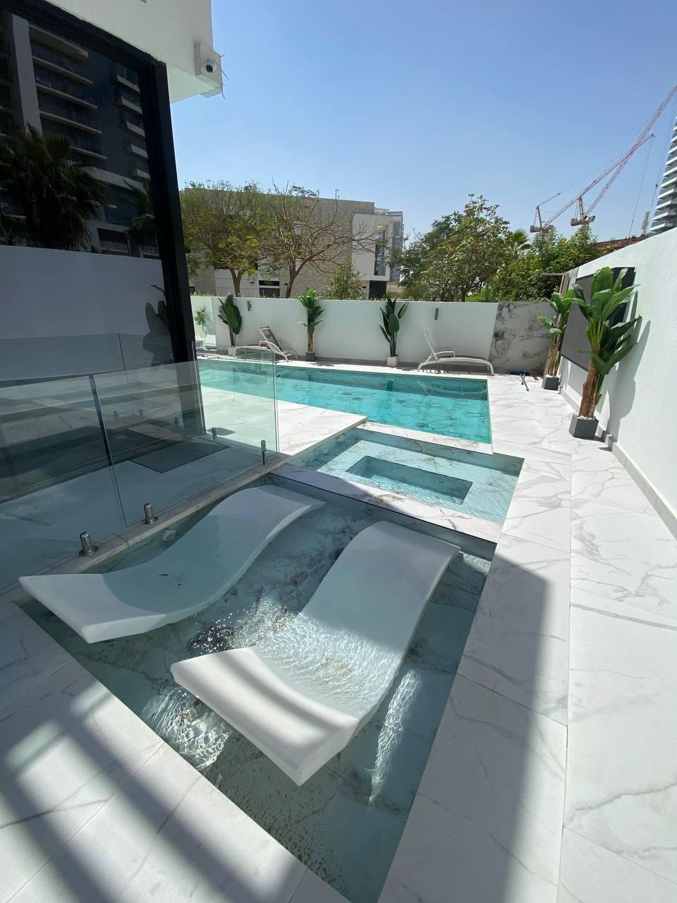 Marble pool with lounge chairs at dusk