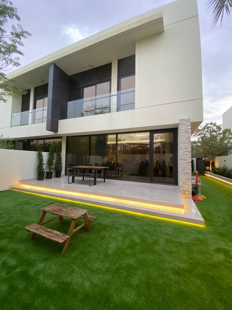 Glass-wall pool lit at night with marble steps