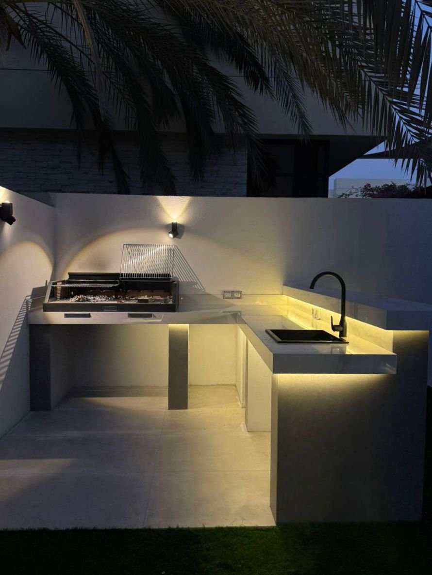 Palm-fronted garden with porcelain paving and hedging border