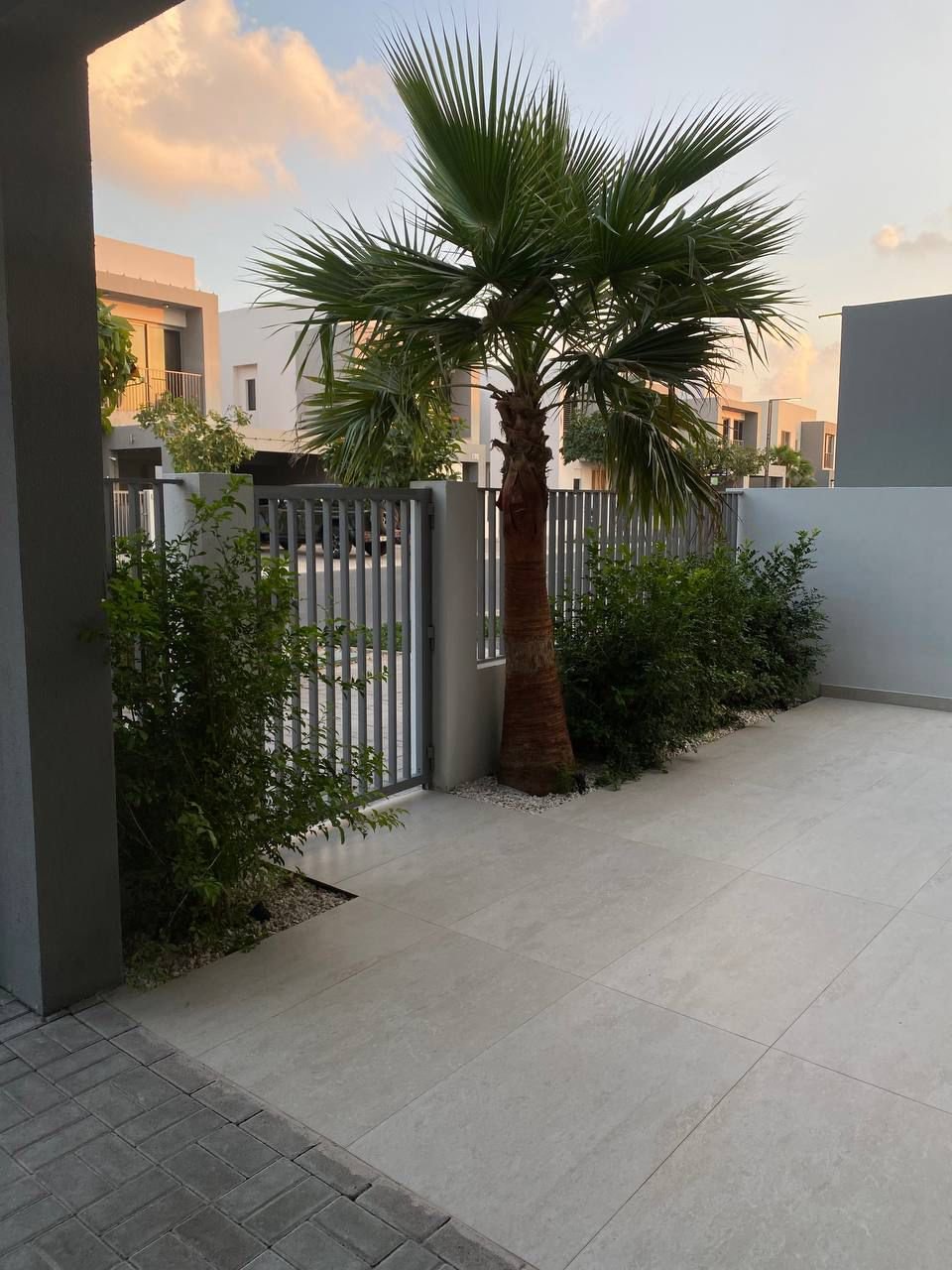 Outdoor kitchen with pergola, pool view and lush planting
