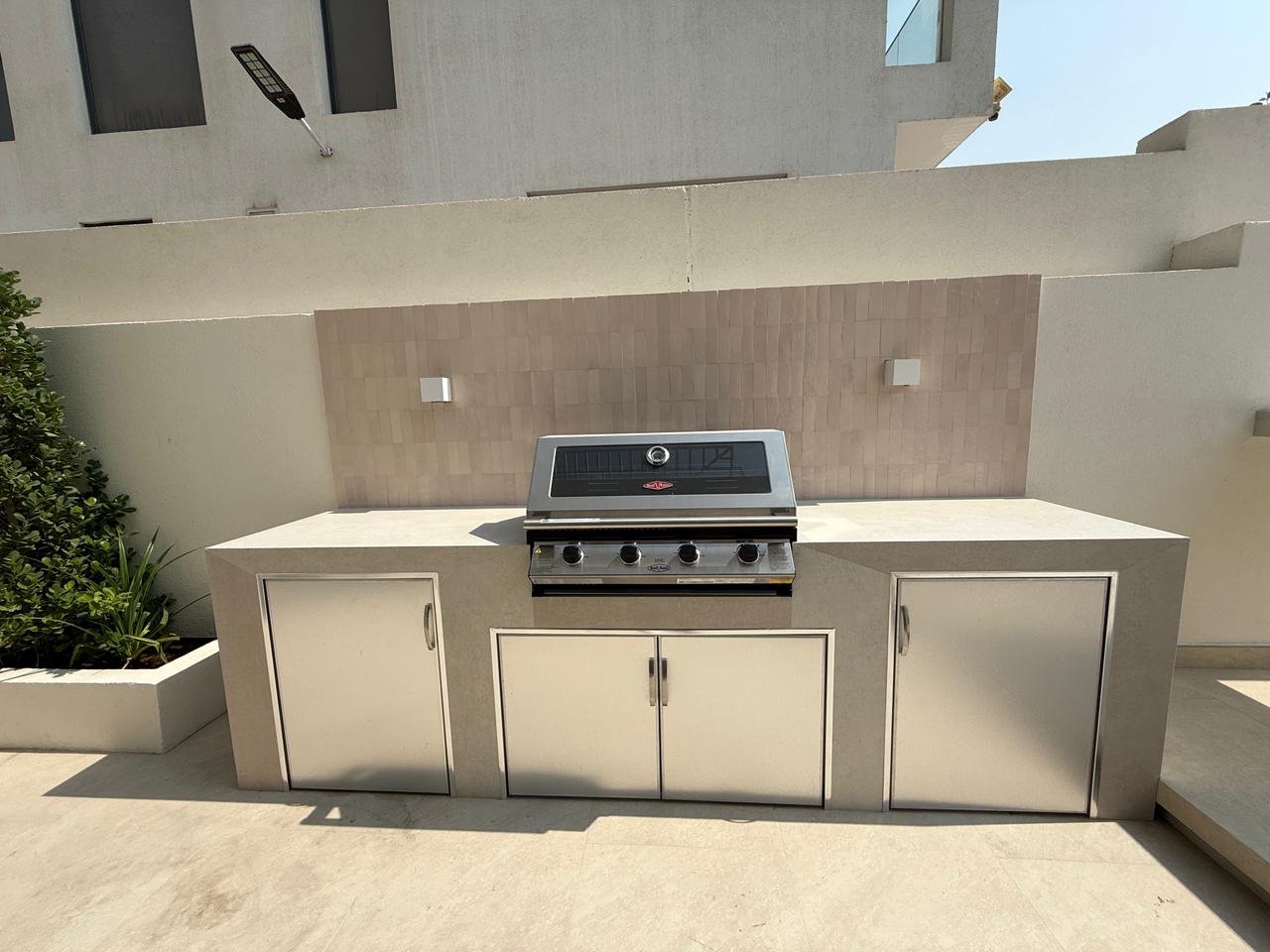 Modern dark steel flat-roof pergola with vertical fins on turf