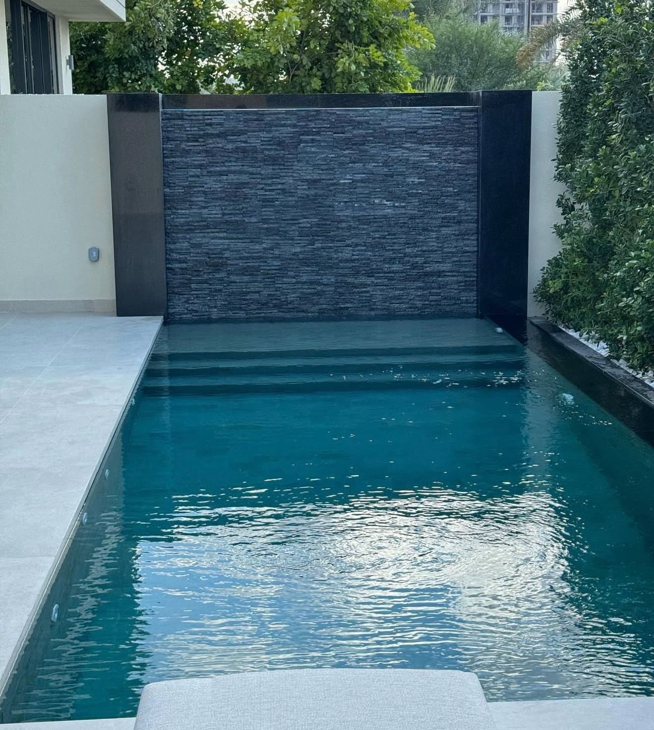 Dark-tiled pool with waterfall feature