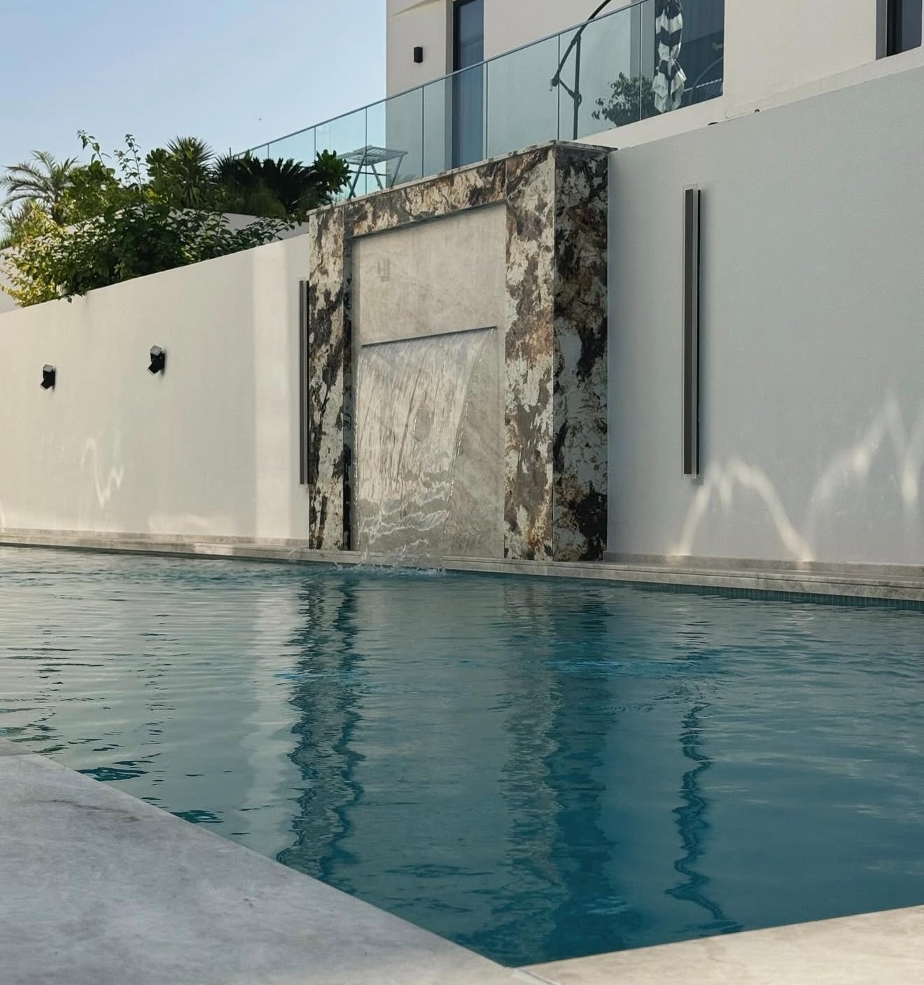 Pool with marble waterfall feature