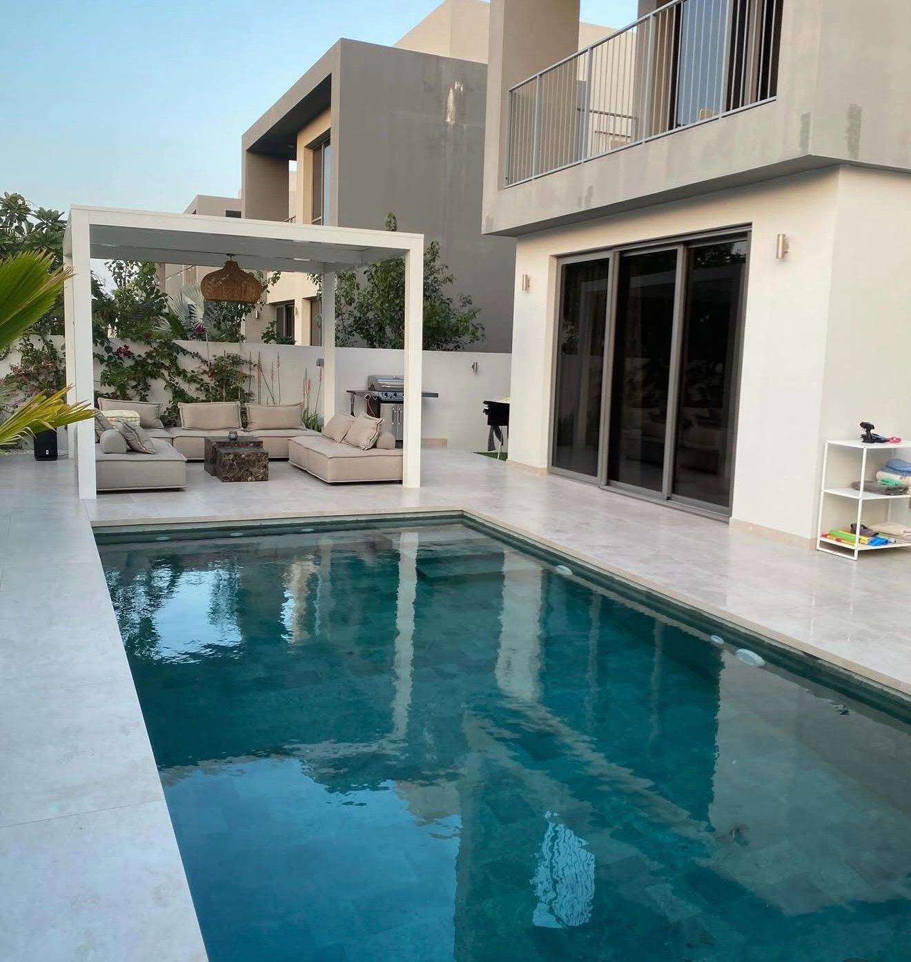 Luxury pool with white pergola lounge area by Formed by Stone Dubai