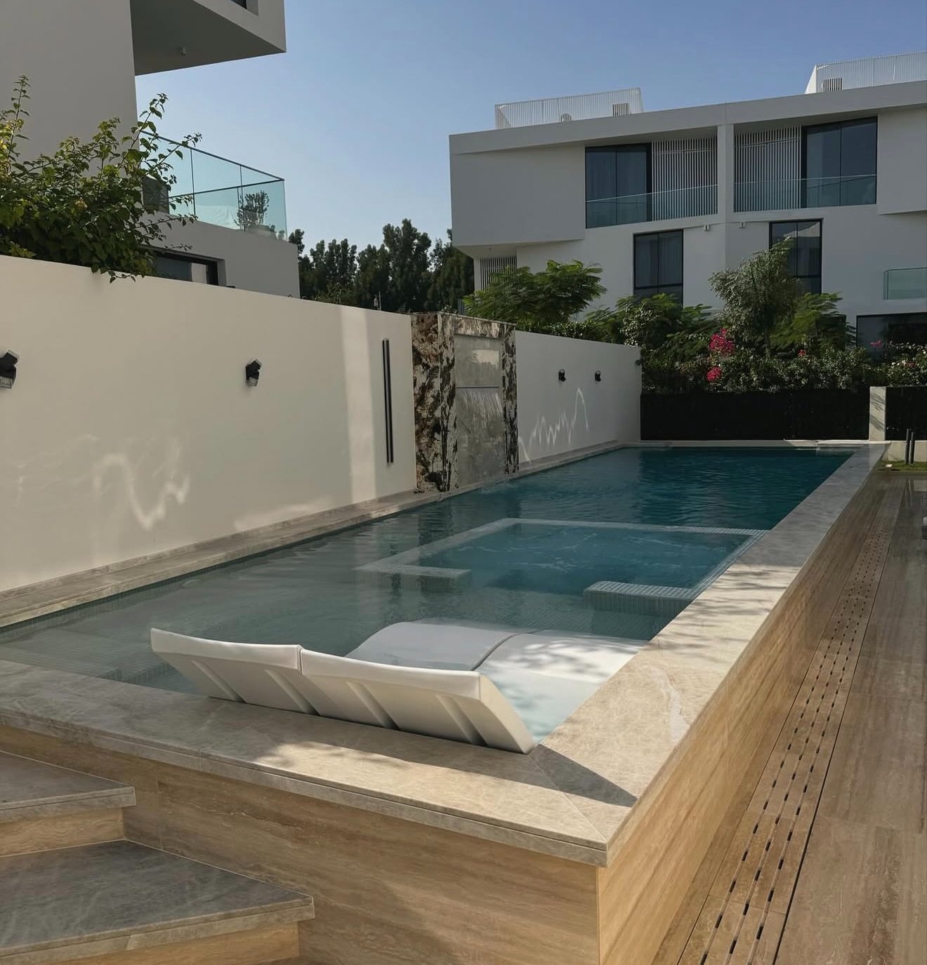 Pool with timber deck and waterfall wall